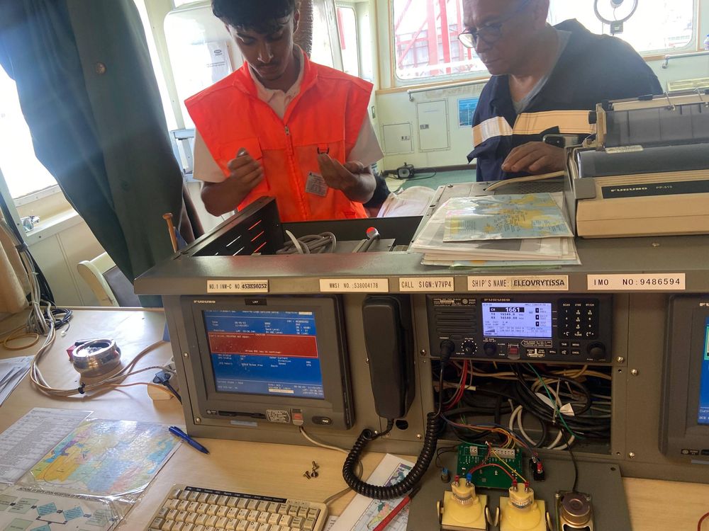 Techniciens Expertronics en intervention sur une station radio de bord en passerelle de navire