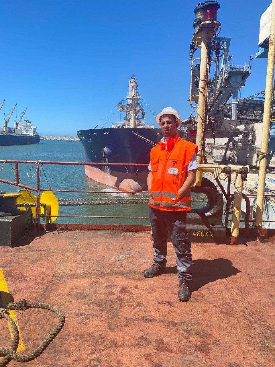 Technicien Expertronics sur le pont d'un navire vraquier à quai dans un port marocain